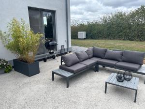 a couch and a coffee table in front of a house at La maison du Gouty in Froid-Chapelle