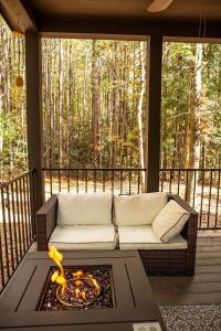 un canapé sur une véranda avec un foyer dans l'établissement Tiny Home Lookout Mountain - Near Downtown & Falls, à Mentone