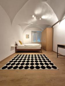 a bedroom with a bed and a checkered rug at Walter Apartment City Center in Ljubljana