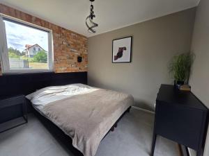a bedroom with a bed and a window at BOSKO domki z balią i sauną przy Gdańsku in Sulmin