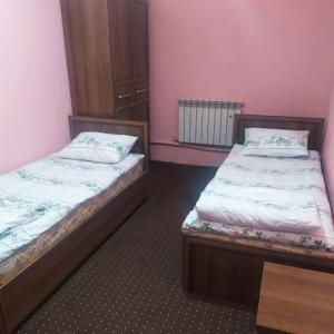 two beds in a room with pink walls at BekHotel in Muruntau