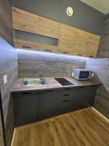 a kitchen with a sink and a microwave at Loft apartment in Kouvola