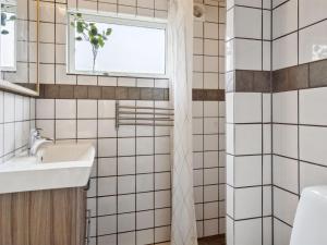a bathroom with a sink and a window at Holiday Home Dome - 12km from the sea by Interhome in Rønde