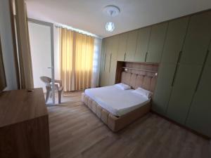a bedroom with a bed and a table and a chair at Rafaele in Shëngjin