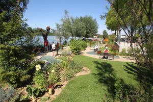 een park met mensen op een bankje bij het water bij Appartement calme et spacieux, tout équipé in Saint-Quentin