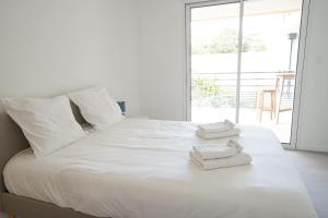 ein Schlafzimmer mit einem weißen Bett mit Handtüchern darauf in der Unterkunft Joli appartement dans le centre des Herbiers in Les Herbiers