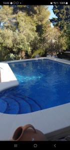 a pair of shoes sitting next to a blue swimming pool at maison nathalia in Jávea +9 photos