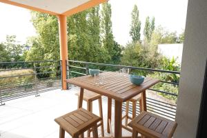 ein Holztisch und zwei Stühle auf einem Balkon in der Unterkunft Joli appartement dans le centre des Herbiers in Les Herbiers