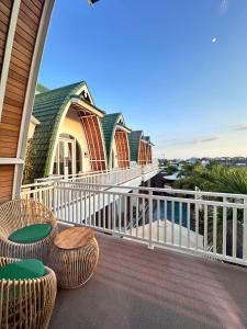 PererenanにあるJasmine River Guest Houseの2つのスツールと椅子が置かれた家のバルコニー