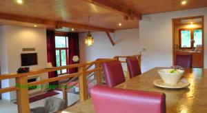 a dining room with a table and red chairs at Le Green Chalet in Villard-sur-Boëge