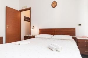 Un dormitorio con una gran cama blanca con toallas. en Parcheggio Privato - 10 Min Centro Storico, en Génova 19 fotos más