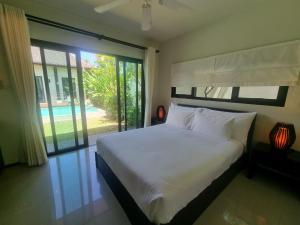 a bedroom with a bed and a large window at Tara13-Oriental Villa 3BR private pool Layan Beach in Bang Tao Beach +23 photos