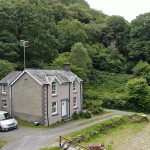 a small house with a car parked in front of it at Tan-Y-Garth Cottage Snowdonia in Conwy