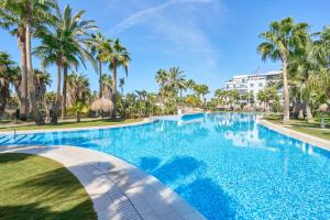 basen z palmami i budynek w tle w obiekcie Paraiso Tropical w mieście Motril
