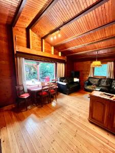 a living room with a table and chairs in a cabin at Natur pur, Haus mit großen Garten am Wald in Langendorf