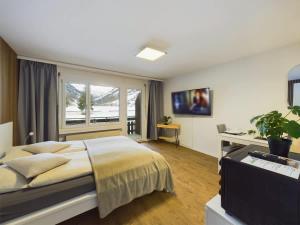 a bedroom with a large bed and a window at Panorama hideaway apartment near Zermatt with parking! in Täsch