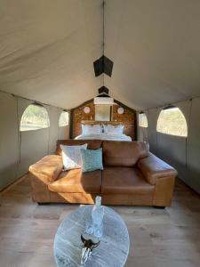 a living room with a couch and a bed in a tent at Vrede Luxury Tented Camp in Kosmos