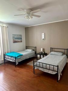 a bedroom with two beds and a ceiling fan at Hannah House South Cozy country living near the city in Thomaston +42 photos