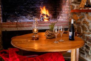a wooden table with wine glasses and a fireplace at Canyon Cottage in Cloeteskraal