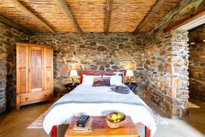a bedroom with a bed with a bowl of fruit on a table at Canyon Cottage in Cloeteskraal