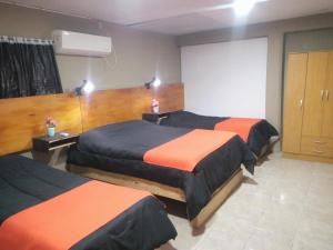 a hotel room with three beds and a screen at Don Mario in San Luis