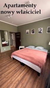 une chambre avec un grand lit recouvert d'une couverture rouge dans l'établissement APARTAMENTY NA EVEREŚCIE W ŚCISŁYM CENTRUM Ul DWORCOWA PARKING GRATIs!, à Bydgoszcz