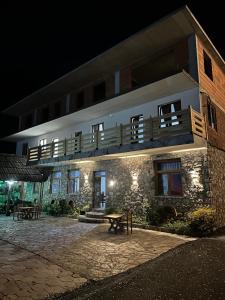 a building with a table in front of it at night at Guesthouse Dritan Selimaj in Valbonë