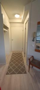 a hallway with a white door and a rug at Pirkkala keskusta rauhallinen kolmio in Tampere +4 photos