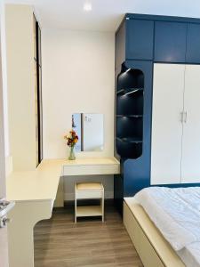 Long BìnhGrace Home Airb&b Apartment的一间卧室，配有一张床和一张带镜子的书桌