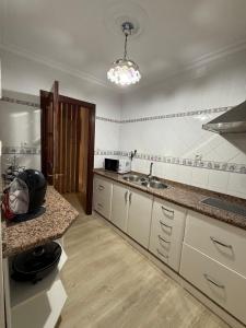 a kitchen with white cabinets and a sink and a counter at Precioso apartamento totalmente reformado in Alcalá de Guadaira