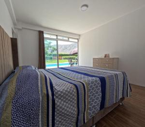 ein Schlafzimmer mit einem Bett und einem großen Fenster in der Unterkunft Casa campo las Pecanas Huaral  + 40 Fotos
