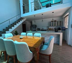 eine Küche und ein Esszimmer mit einem Holztisch und Stühlen in der Unterkunft Casa campo las Pecanas Huaral 