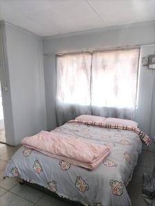 a bed in a room with a window at Sunflower Stays in Pretoria