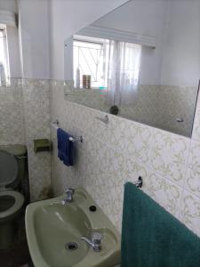 a bathroom with a sink and a toilet and a mirror at Sunflower Stays in Pretoria