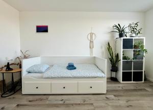 a bedroom with a white bed and a white cabinet at Downtown Apartment in Trnava