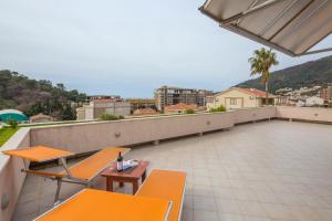 a balcony with two orange chairs and a table at Petrovac Holiday Apartments in Petrovac na Moru