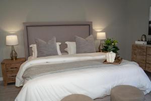 a bedroom with a large white bed with pillows at Kénōsis Guestfarm - Room 1 in Springbok