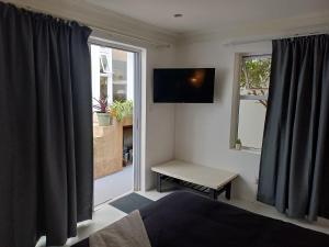 德班Rosetta Cottage的一间带床、电视和窗户的卧室