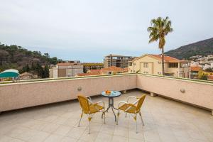 un patio con 2 sillas y una mesa en el balcón en Petrovac Holiday Apartments, en Petrovac na Moru