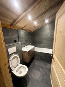 een badkamer met toilet, wastafel en bad bij Résidence Valmonts A - Appartement duplex rénové · Départ ski aux pieds · Balcon MAE-9904 in Les Bruyères