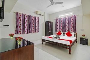 a bedroom with a bed with red pillows at Hotel O Star in Kharadi