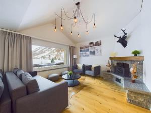 a living room with a couch and a fireplace at Mountain Majesty Apartment with Stunning Views in Täsch
