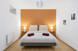 a bedroom with a bed with two pillows on it at Le Prestige Mâconnais Calme Central Luxe in Mâcon