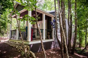 a small house with a balcony in the woods at Cricket by the Creek - Creek, Gym, Trails, Kayaks in Menlo