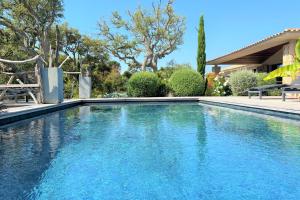 a swimming pool with blue water in a yard at Villa Pignotulli Di Cirendinu in Sainte-Lucie de Porto-Vecchio