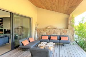 a living room with a couch and a table at Villa Pignotulli Di Cirendinu in Sainte-Lucie de Porto-Vecchio +20 photos