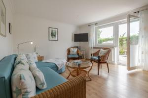 a living room with a blue couch and a table at Meer in Süderende