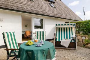 a table with two chairs and a table with a tablecloth at Meer in Süderende