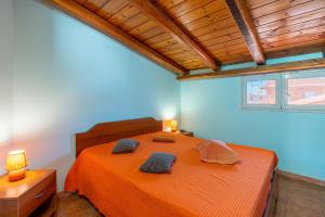 a bedroom with an orange bed with two pillows on it at Casa Pina a due passi dal mare in Augusta