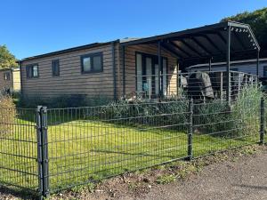 a fence in front of a tiny house at Ostseecamp Ferienhaus "Sauerländer" in Scharbeutz